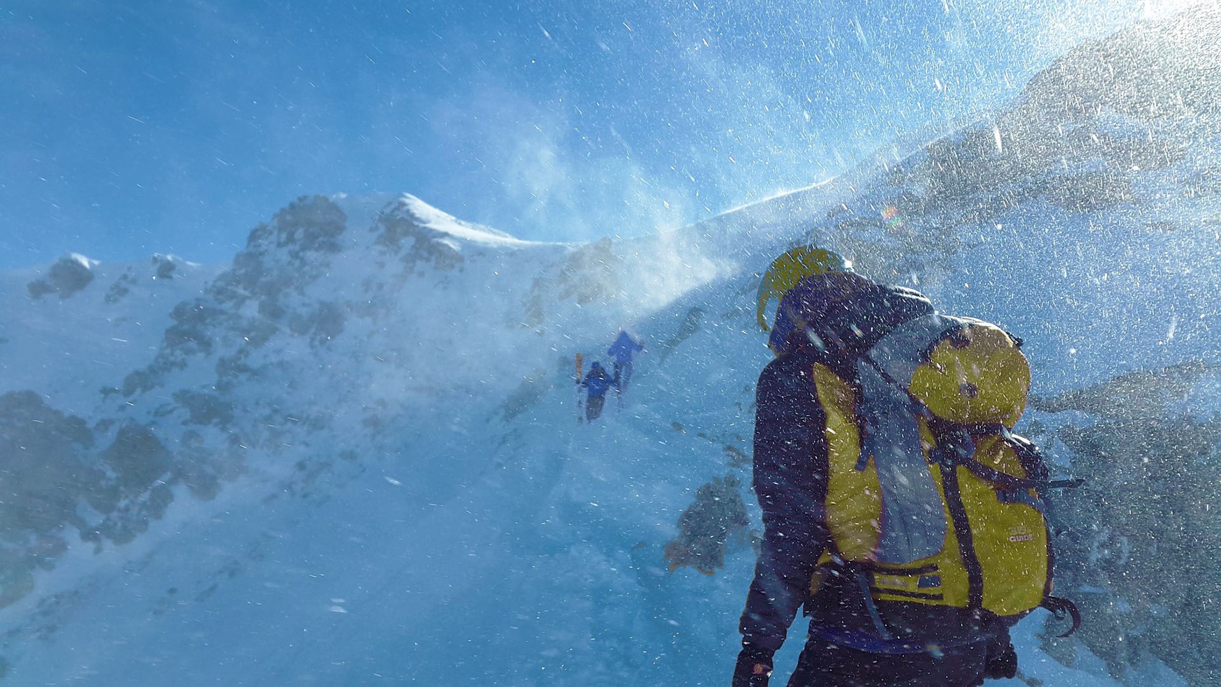 Bergbeklimmer op besneeuwde berg in slechte weersomstandigheden.